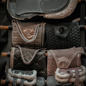 Organized display of various equestrian saddle pads in Balkasodis, Lithuania.